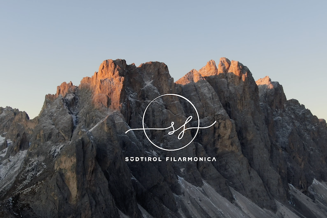 Berge mit Logo von Südtirol Filarmonica im Vordergrund